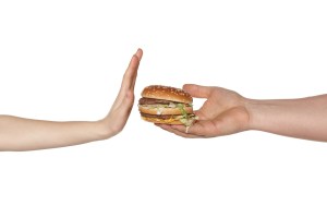 Female hand refusing the fast food meal